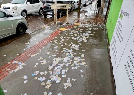 Chuva 'cola' santinhos no chão em frente a escola eleitoral no Coophavila II